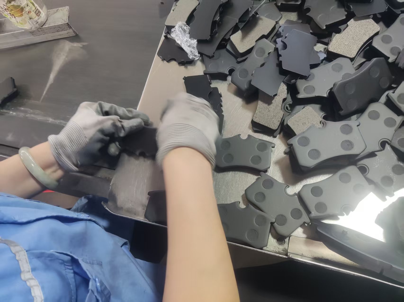 Hands-on assembly work with brake pads and backing components.